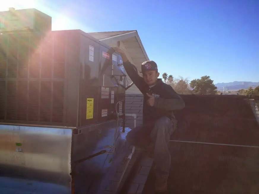 HVAC technician performing HVAC Inspection on a rooftop unit in Center